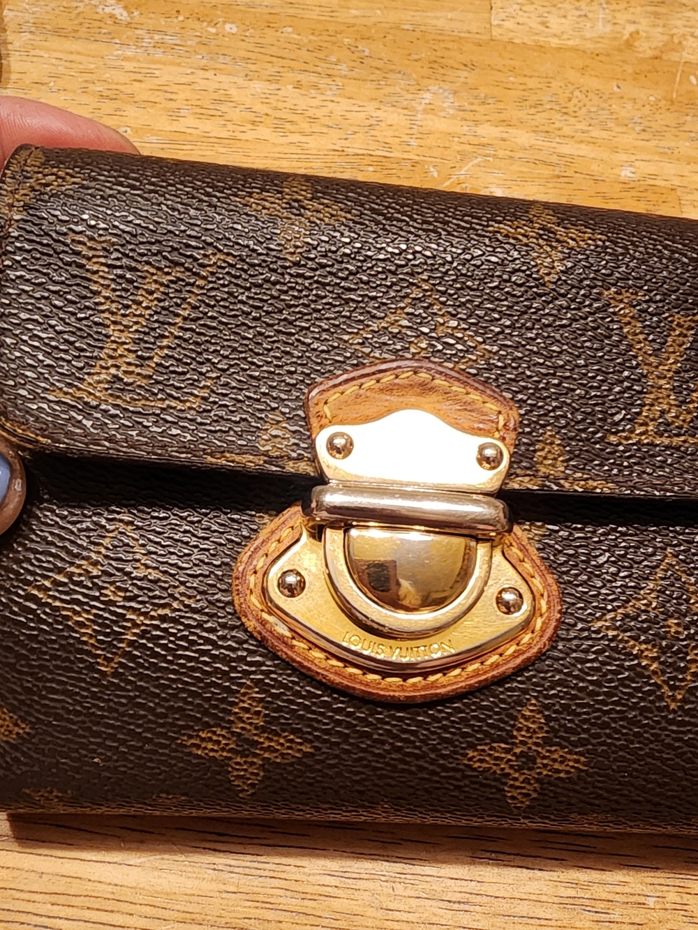 Louis Vuitton Monogram Joey Wallet in brown coated canvas a push-lock closure